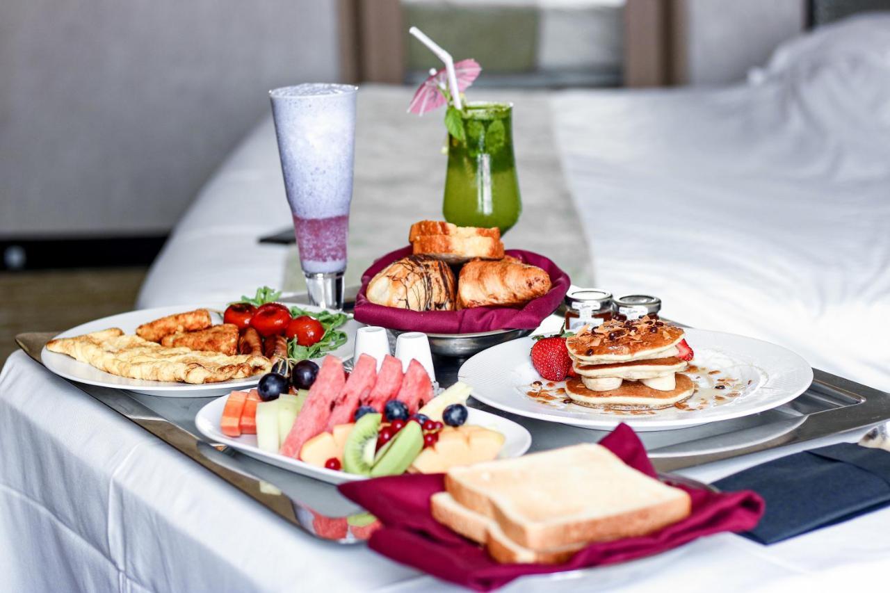 Hotel Millennium Plaza Doha Exterior foto The photo showcases a delicious breakfast spread arranged on a tray. There are several plates featuring a variety of food items, including:

- A selection of pastries such as croissants and possibly muffins or rolls.
- A colorful assortment of fresh 