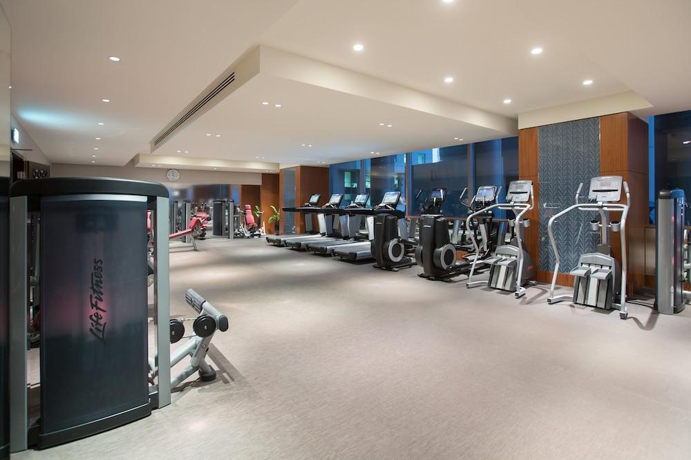 Hotel Millennium Plaza Doha Exterior foto The photo shows a modern gym interior. It features various exercise machines, including treadmills, elliptical machines, and weight equipment. The space is well-lit with overhead lights, and there are large windows allowing natural light to enter. Th