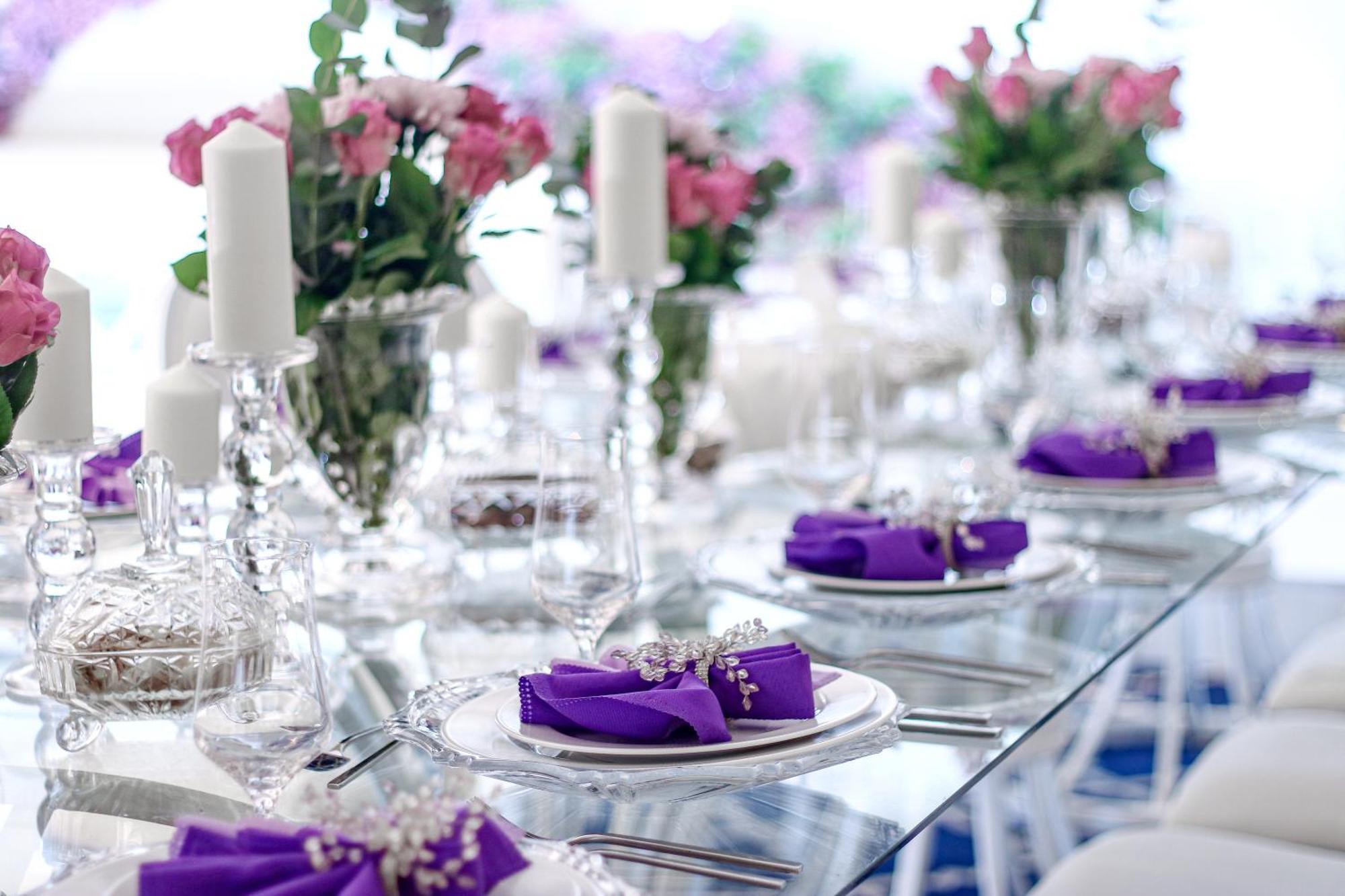 Hotel Millennium Plaza Doha Exterior foto The photo shows an elegantly set dining table. The table has a glass surface and is adorned with fine tableware. Each place setting includes a plate with a purple napkin folded elegantly and possibly embellished with decorative elements. 

There are 