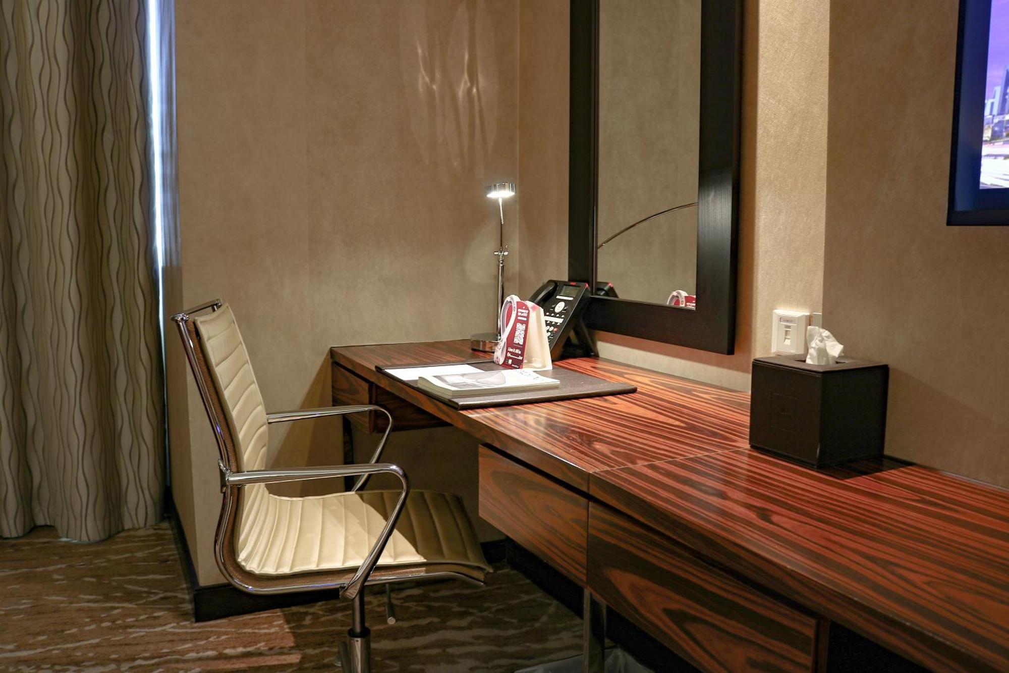 Hotel Millennium Plaza Doha Exterior foto A writing desk in a hotel room